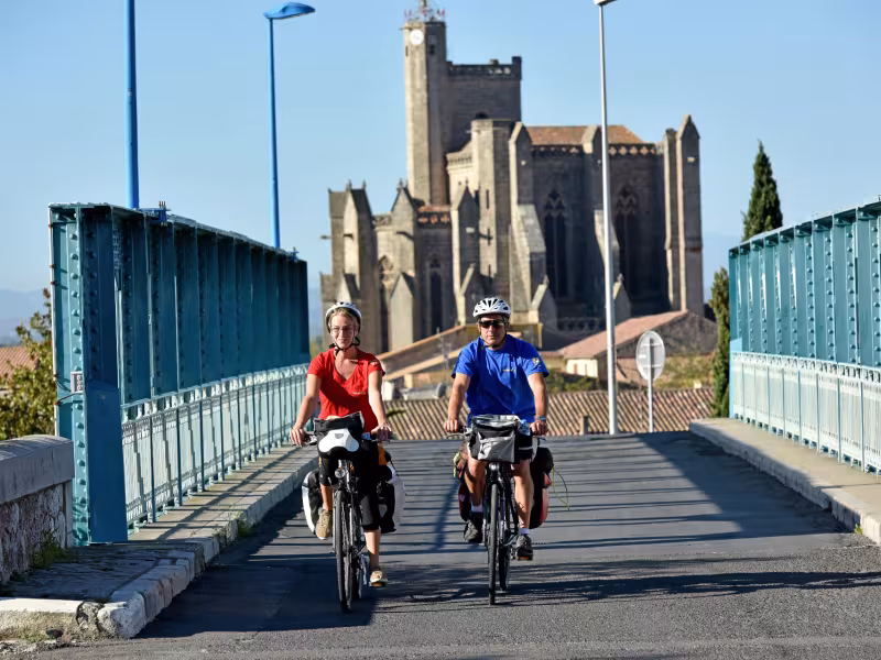 Cyclistes devant le collégiale Saint-Étienne de Capestang 