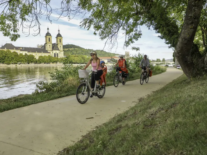 Famille à vélo sur le halage de la Moselle à Pont-à-Mousson devant l'abbaye des Prémontrés