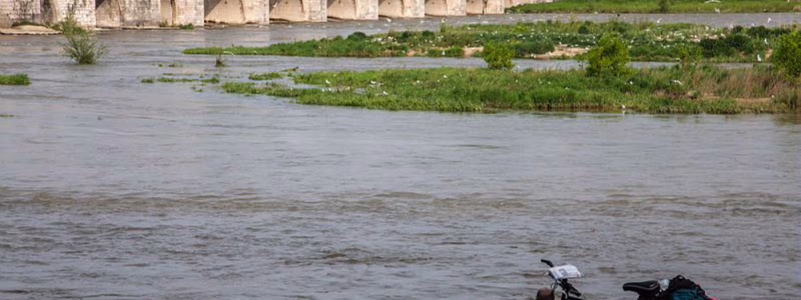 Pause d'un voyageur à vélo près d'un pont sur Loire - Beaugency