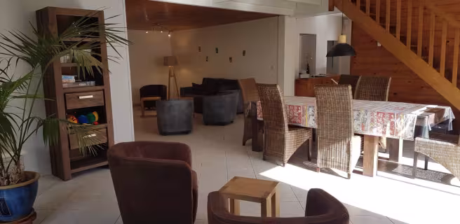 Grand salon/salle à manger avec escalier en bois menant à l'étage